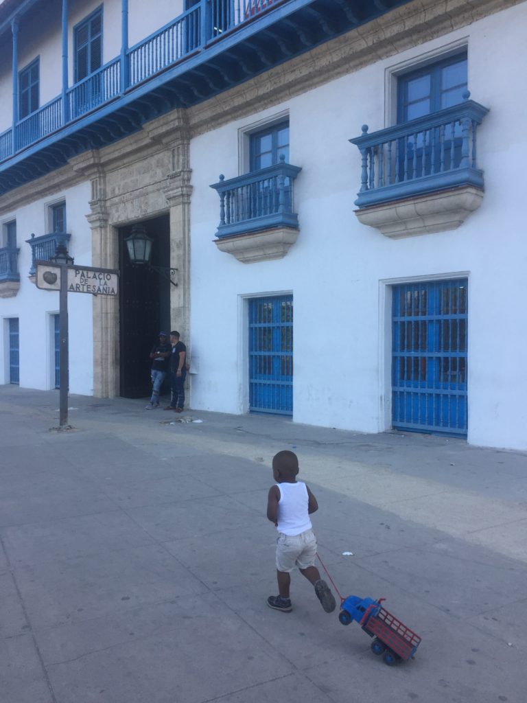 Kid playing in front of Casa de la Artesania