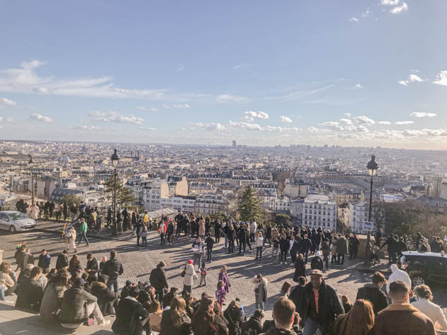 There were many people sitting on the stairs by the Sacré Coeur