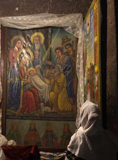 Woman praying inside a rock-hewn church in Lalibela