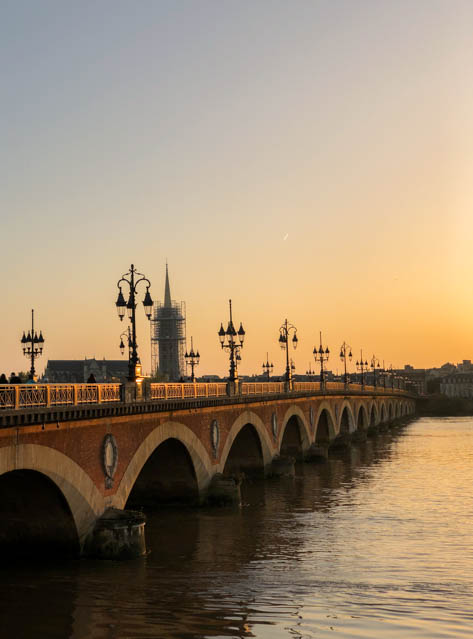 Pont de Pierre at sunset with the Basilique de Saint-Michel in the background